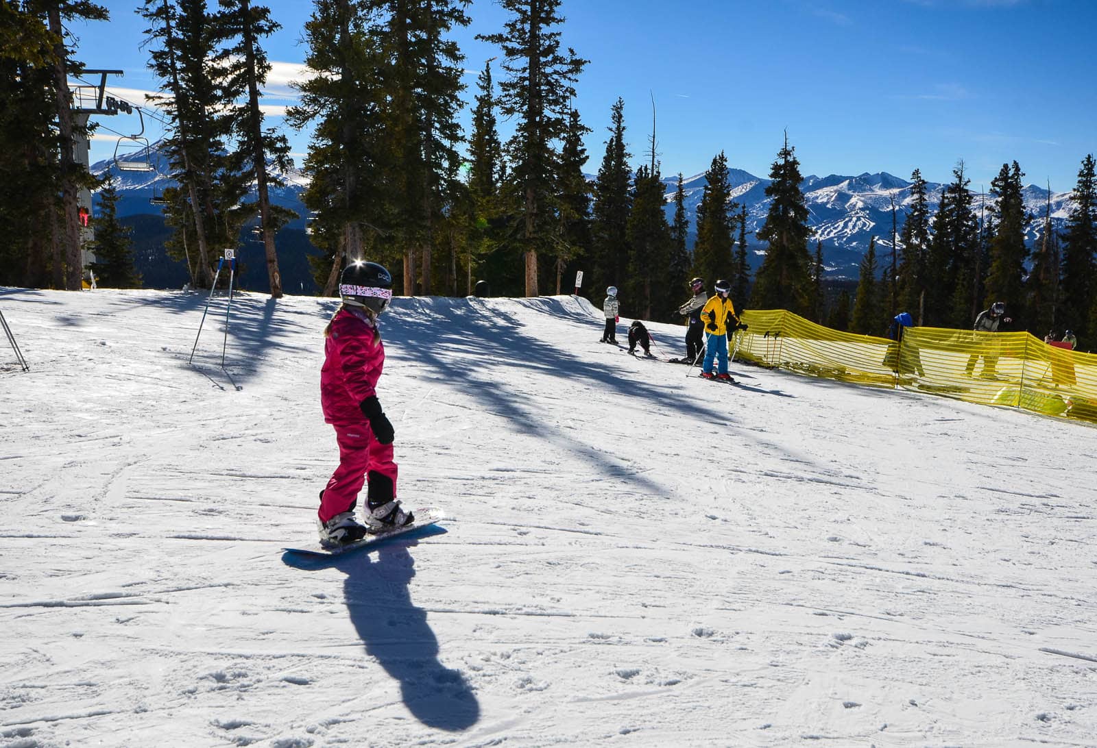 Young girl snowboarder, dressed all in pink, at Keystone in Colorado.