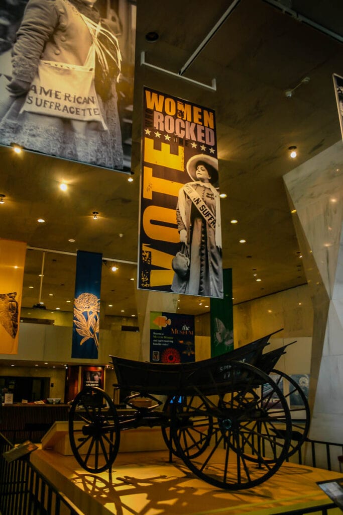 New York Suffragettes museum exhibit at the New York State Capital with banners and 1716 wagon.