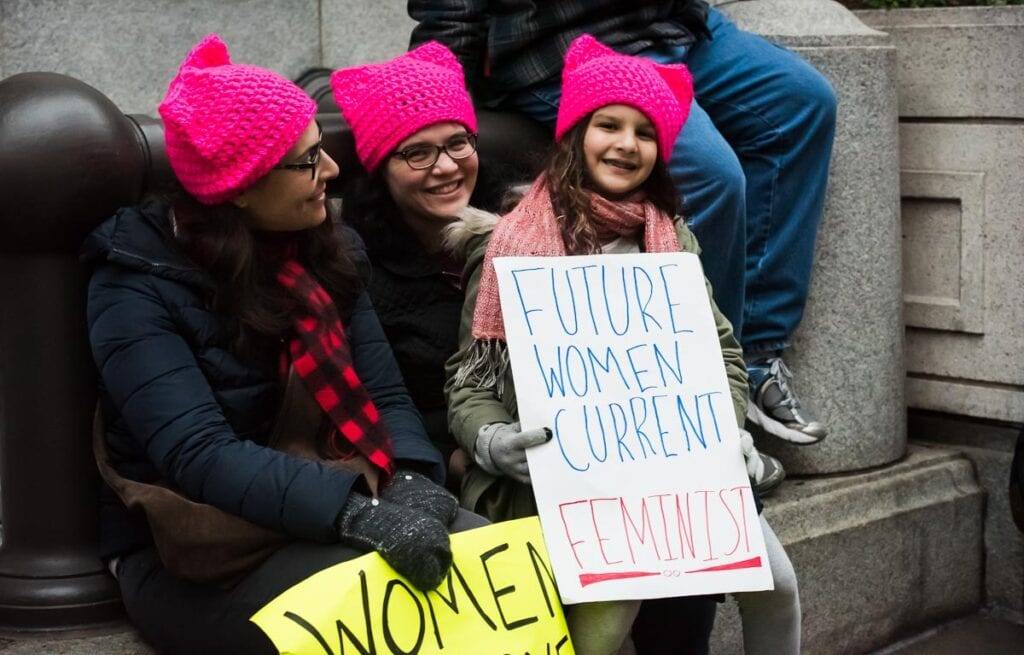 Young girl holds up sign that says "Future Woman, Current Feminist" at Women's Rights Protest in Washington DC in January 2017.