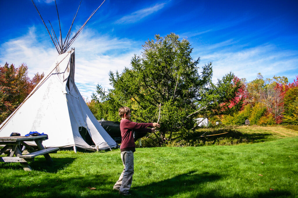 Boy practices archery at wilderness program in Dyken Pond.